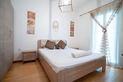 a bedroom with a bed with white sheets and a window at City Link Gyzi by MPS in Athens