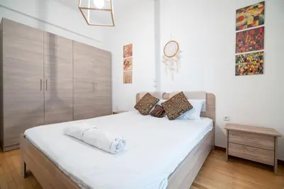 a bedroom with a large white bed with a wooden headboard at City Link Gyzi by MPS in Athens