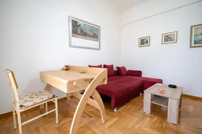 a living room with a red couch and a table at City Link Gyzi by MPS in Athens