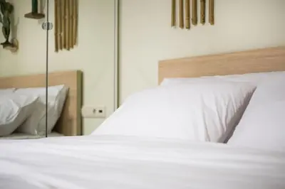 a bedroom with two white beds and a mirror at A comfortable small studio nearby Acropolis 2 in Athens