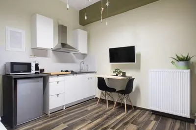 a kitchen with white cabinets and a sink and a microwave at A comfortable small studio nearby Acropolis 2 in Athens
