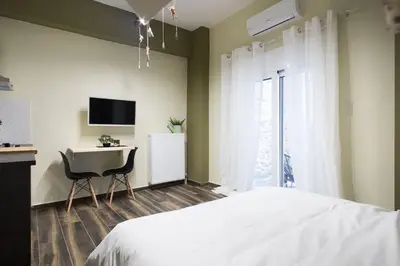 a bedroom with a bed and a desk and a television at A comfortable small studio nearby Acropolis 2 in Athens