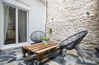 a patio with a wooden table and two chairs at A comfortable small studio nearby Acropolis 2 in Athens