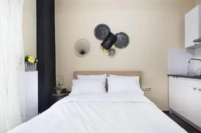 a bedroom with a white bed with two hats on the wall at A comfortable small studio nearby Acropolis 3 in Athens