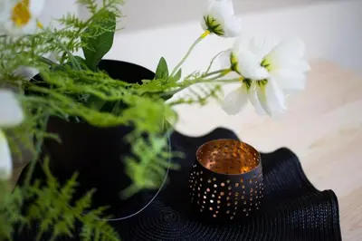 a black candle sitting next to a vase with flowers at A comfortable small studio nearby Acropolis 3 in Athens