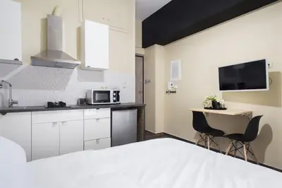 a room with a bed and a kitchen with a microwave at A comfortable small studio nearby Acropolis 3 in Athens
