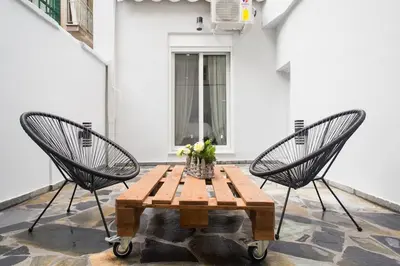 two chairs and a wooden table with a table and two chairs at A comfortable small studio nearby Acropolis 3 in Athens