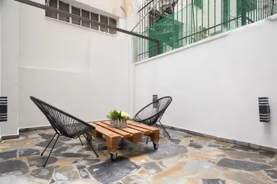 a patio with two chairs and a wooden table at A comfortable small studio nearby Acropolis 3 in Athens