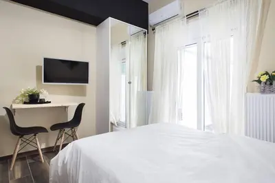 a bedroom with a bed and a desk and a tv at A comfortable small studio nearby Acropolis 3 in Athens