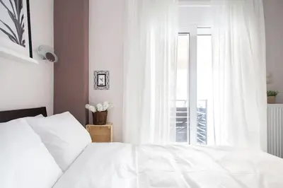 a bedroom with a white bed and a window at A comfortable small studio nearby Acropolis 4 in Athens