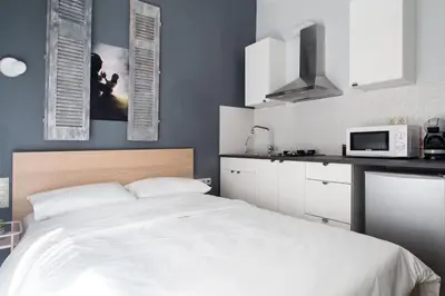 a bedroom with a white bed and a microwave at A comfortable small studio nearby Acropolis 5 in Athens
