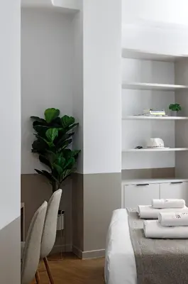a bedroom with a bed and two chairs and a plant at ERMASS Athens in Athens