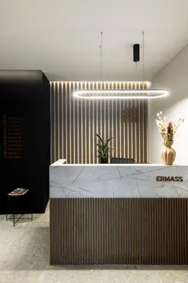 a lobby with a reception desk with a vase of flowers at ERMASS Athens in Athens