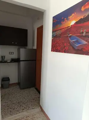 a room with a flat screen tv and a refrigerator at Διαμέρισμα 1 ΣΤΗΝ ΑΓΙΑ ΜΑΡΙΝΑ in Agia Marina Aegina