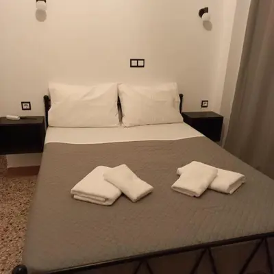 a bed with two white towels on top of it at Διαμέρισμα 1 ΣΤΗΝ ΑΓΙΑ ΜΑΡΙΝΑ in Agia Marina Aegina