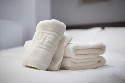 a pile of towels sitting on top of a bed at A comfortable small studio nearby Acropolis 201 in Athens