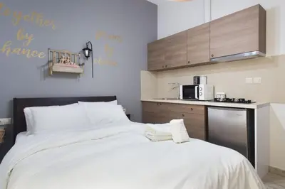 a bedroom with a large bed and a kitchen at A comfortable small studio nearby Acropolis 201 in Athens
