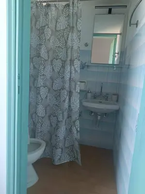 a bathroom with a sink and a shower curtain at Διαμέρισμα 2 ΣΤΗΝ ΑΓΙΑ ΜΑΡΙΝΑ in Agia Marina Aegina