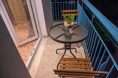 a glass table and chairs on a balcony at Διαμέρισμα 3 ΣΤΗΝ ΑΓΙΑ ΜΑΡΙΝΑ in Agia Marina Aegina
