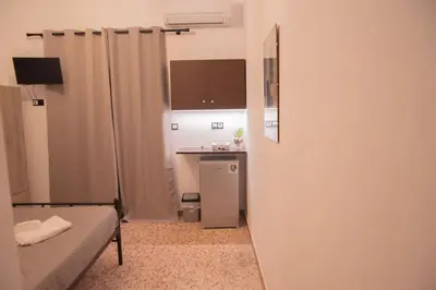 a small room with a bed and a small kitchen at Διαμέρισμα 3 ΣΤΗΝ ΑΓΙΑ ΜΑΡΙΝΑ in Agia Marina Aegina