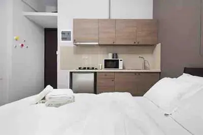 a bedroom with two white beds and a kitchen at A comfortable small studio nearby Acropolis 202 in Athens