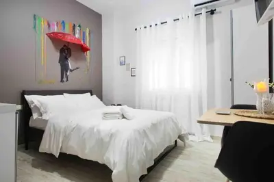 a bedroom with a bed with a red umbrella at A comfortable small studio nearby Acropolis 202 in Athens