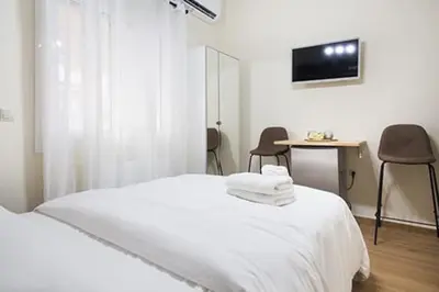 a bedroom with a bed and a desk and a television at A comfortable small studio nearby Acropolis 203 in Athens