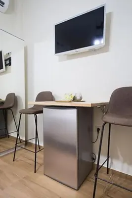 a table with two chairs and a tv on a wall at A comfortable small studio nearby Acropolis 203 in Athens