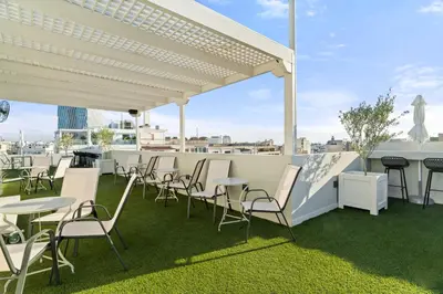 a rooftop patio with tables and chairs on a roof at Gallery Central Piraeus Port in Piraeus