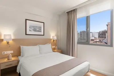 a hotel room with a bed and a large window at Gallery Central Piraeus Port in Piraeus