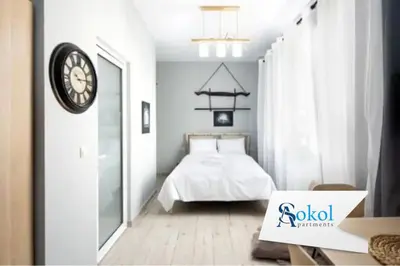 a bedroom with a bed and a clock on the wall at Small studio under Acropolis B! in Athens
