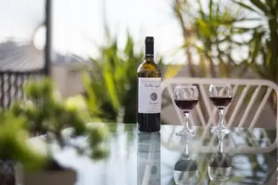 a bottle of wine sitting on a table with two glasses at Small studio under Acropolis B! in Athens