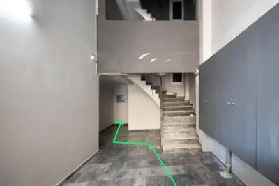 a hallway with a staircase with green lines on the floor at Small studio under Acropolis B! in Athens
