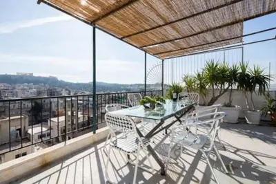 a table and chairs on a balcony with a view at Small studio under Acropolis B! in Athens