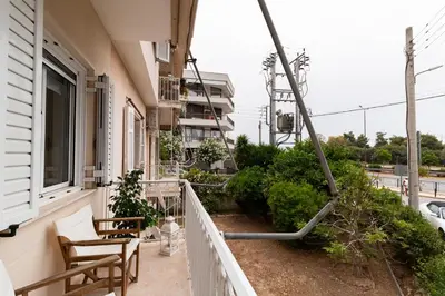 a balcony of a building with chairs and a pole at Edem Beach Apartment by Alimos Marina - Athenian Homes in Athens