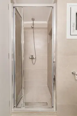a shower with a glass door in a bathroom at Edem Beach Apartment by Alimos Marina - Athenian Homes in Athens