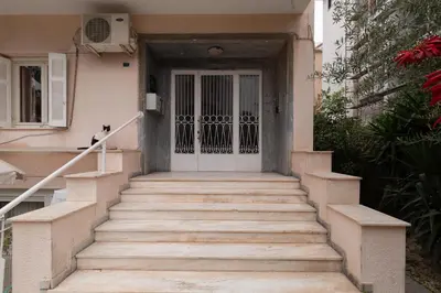a stairway leading to a white door with a cat on it at Edem Beach Apartment by Alimos Marina - Athenian Homes in Athens