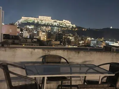 a table and chairs on a ledge with a view of a city at Small studio under Acropolis A! in Athens