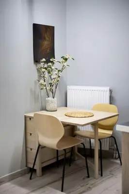 a table with two chairs and a vase with flowers at Small studio under Acropolis A! in Athens