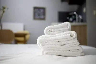 a stack of towels sitting on top of a bed at Small studio under Acropolis A! in Athens