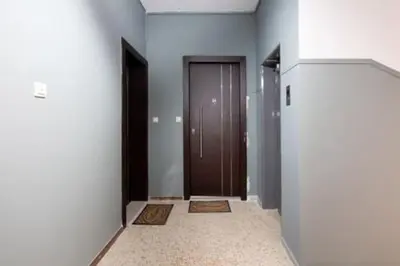 a hallway with two brown doors and a tile floor at Small studio under Acropolis A! in Athens