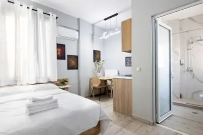 a bedroom with a white bed and a bathroom at Small studio under Acropolis A! in Athens