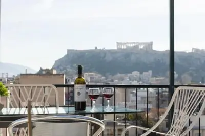 a table with two glasses of wine on a balcony at Small studio under Acropolis A! in Athens