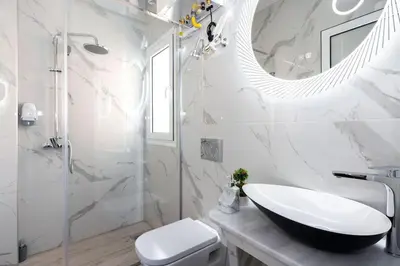 a white bathroom with a sink and a mirror at Small studio under Acropolis A! in Athens