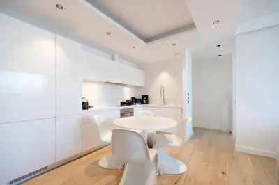 a white kitchen with a white table and white chairs at Top Notch Stay In Kolonaki in Athens