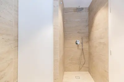 a shower in a bathroom with a stone wall at Top Notch Stay In Kolonaki in Athens
