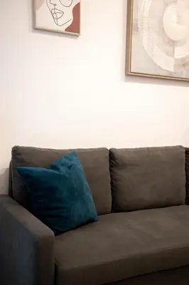 a brown couch with a blue pillow on it at Afroditi in Athens
