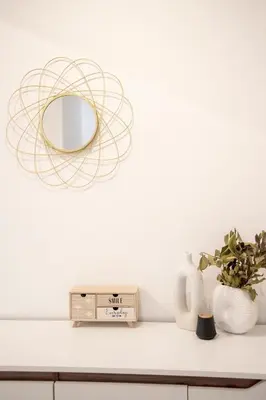 a shelf with a mirror and a clock and vases at Afroditi in Athens