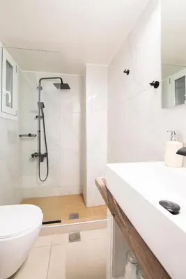 a white bathroom with a shower and a sink at Afroditi in Athens