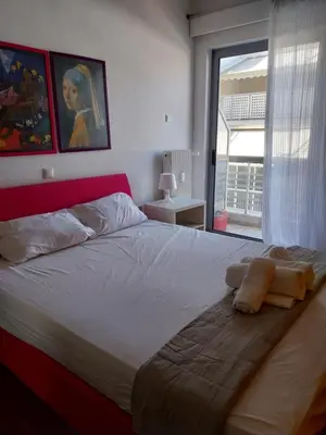 a bedroom with a large bed with a large window at Lucie's Apartment in Athens